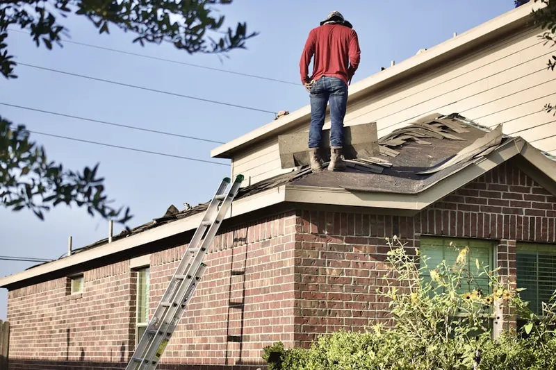 Professional roofer working on a residential roof in Braun Station